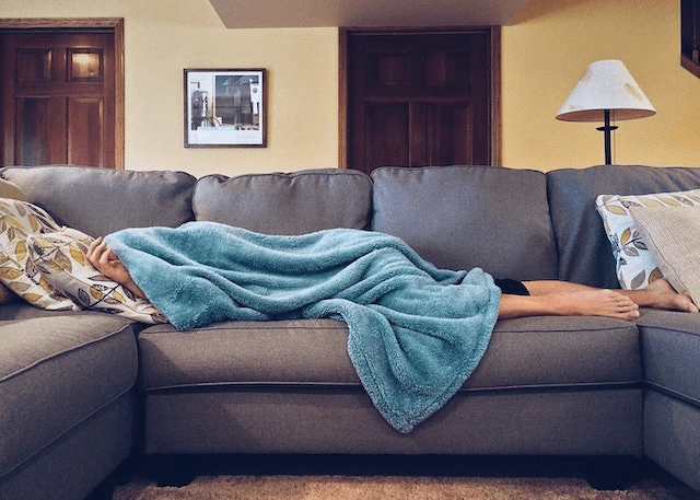 person laying sick on a couch