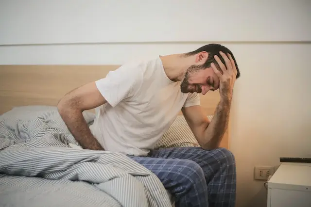 man struggling to wake and get out of bed